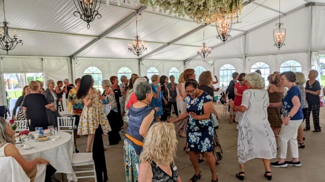 women dancing in white tent at banquet