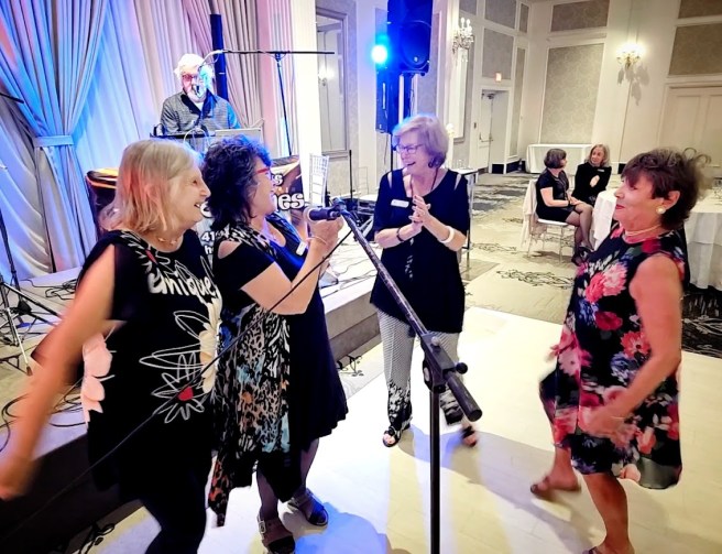4 women singing along at the microphone