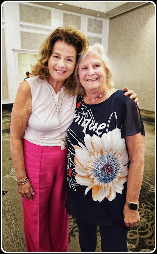 two women smiling and leaning on each other