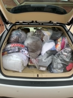 a loaded car trunk with clothing donations