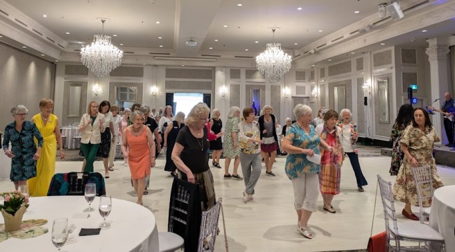 2025_05_27 group of women being led through line dancing