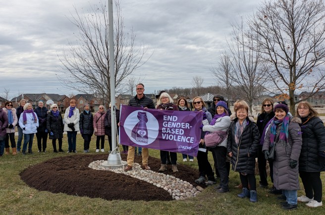 2025_11_25 display of flag raised for ending gender based violence with small crowd